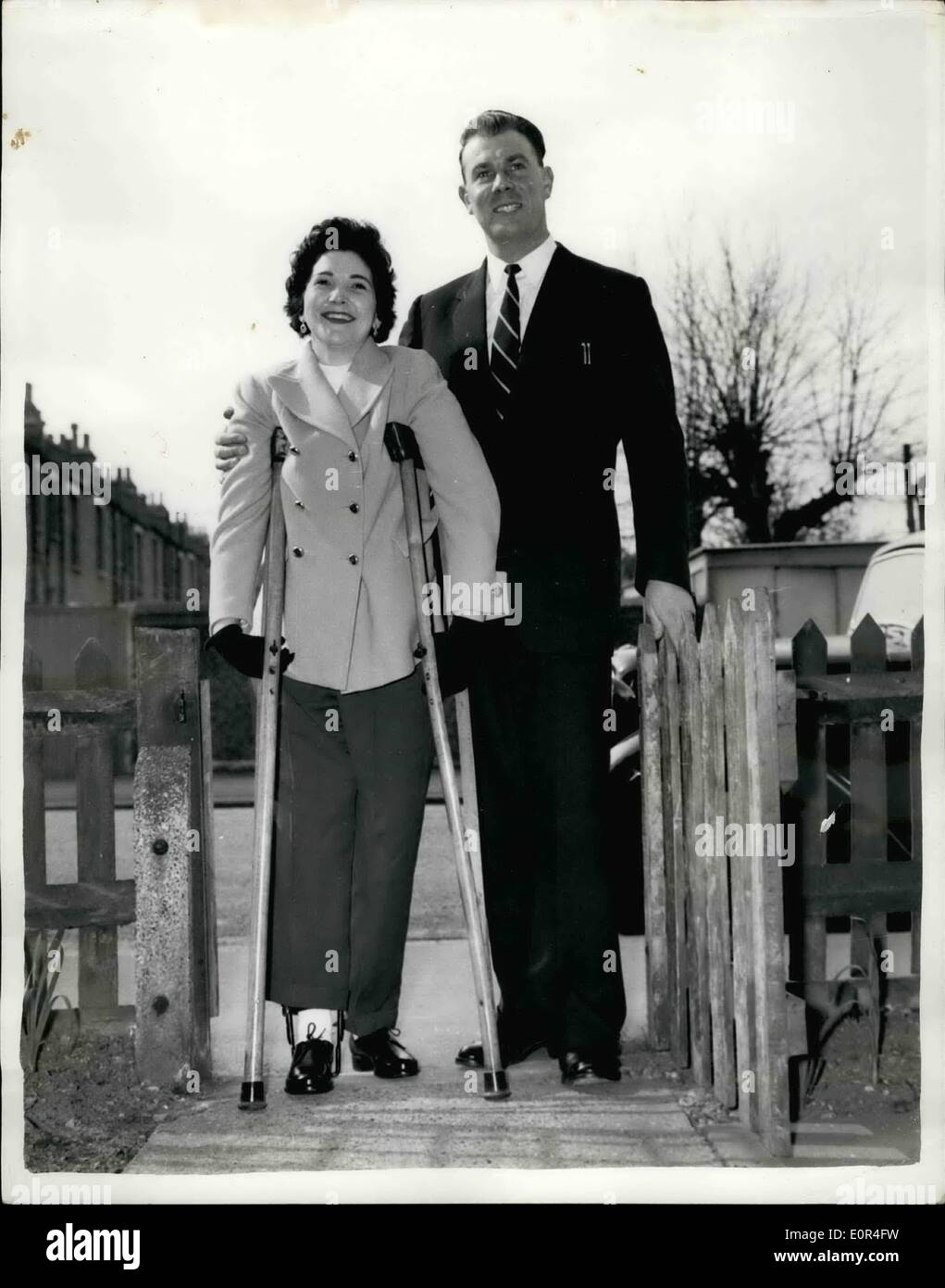 Mar. 03, 1958 - Mrs.Taylor Wins Through And Returns Home For Her First Wedding Anniversary: Mrs. Jo Taylor hobbled up her garden path yesterday or crutches - just 107 days after she was rushed to hospital after the Lewisham train disaster.Doctors said she would be in hospital till April to May, but Mrs. Taylor was determined to be home for her first wedding anniversary on Sunday.Photo Shows Mrs. Jo Taylor accompanied by her husband, Ken, at the garden gate of their home in Penge, London, yesterday. Stock Photo