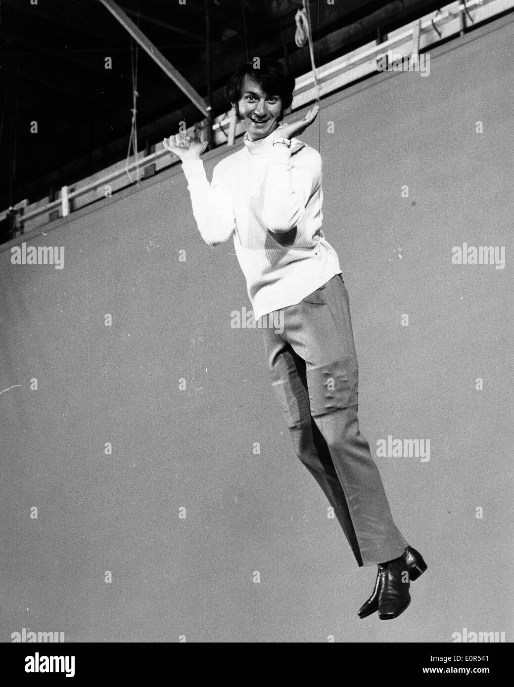 Singer Mike Nesmith swinging in a scene from a new Monkees' film Stock Photo