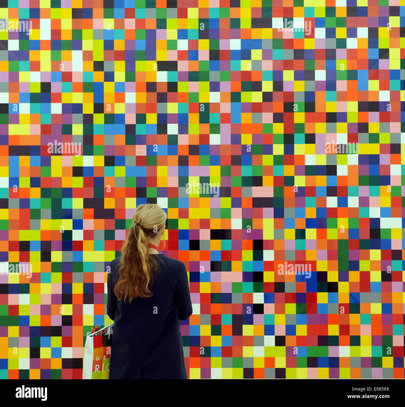 A woman regarding a painting of the series '4900 Farbe' of the german artist Gerhard Richter in the Fondation Beyeler in Riehen near Basel (Switzerland), on May 16, 2014. Stock Photo