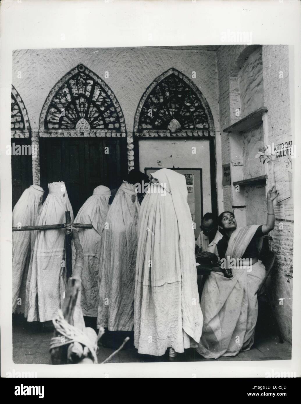 Mar. 25, 1958 - The New and The Old India -Face to Face: Half a million people are estimated to have voted in the recent municipal election in the Old City of Delhi, recently. The white clad figures on the left are Moslem women in purdah. The ment they wear is called a burqa. An emancipated girl (right) shows her sisters how to vote. Stock Photo