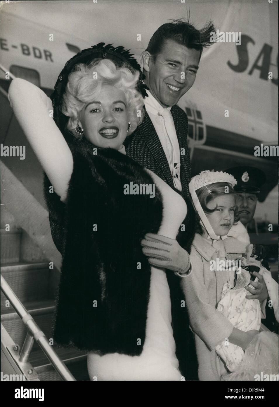 Apr. 04, 1958 - Jayne Mansfield Arrives: Jayne Mansfield, the Hollywood star, arrived at London Airport today. She is to co-star with Kenneth More in the film ''The Sheriff of Fractured Jaw''. She was accompanied by her husband, Mickey Hargitay, and her daughter, Jayne. Photo shows Jayne Mansfield, withe her husband, Mickey Hargitay and her daughter , Jayne, on arrival at London Airport today. Stock Photo
