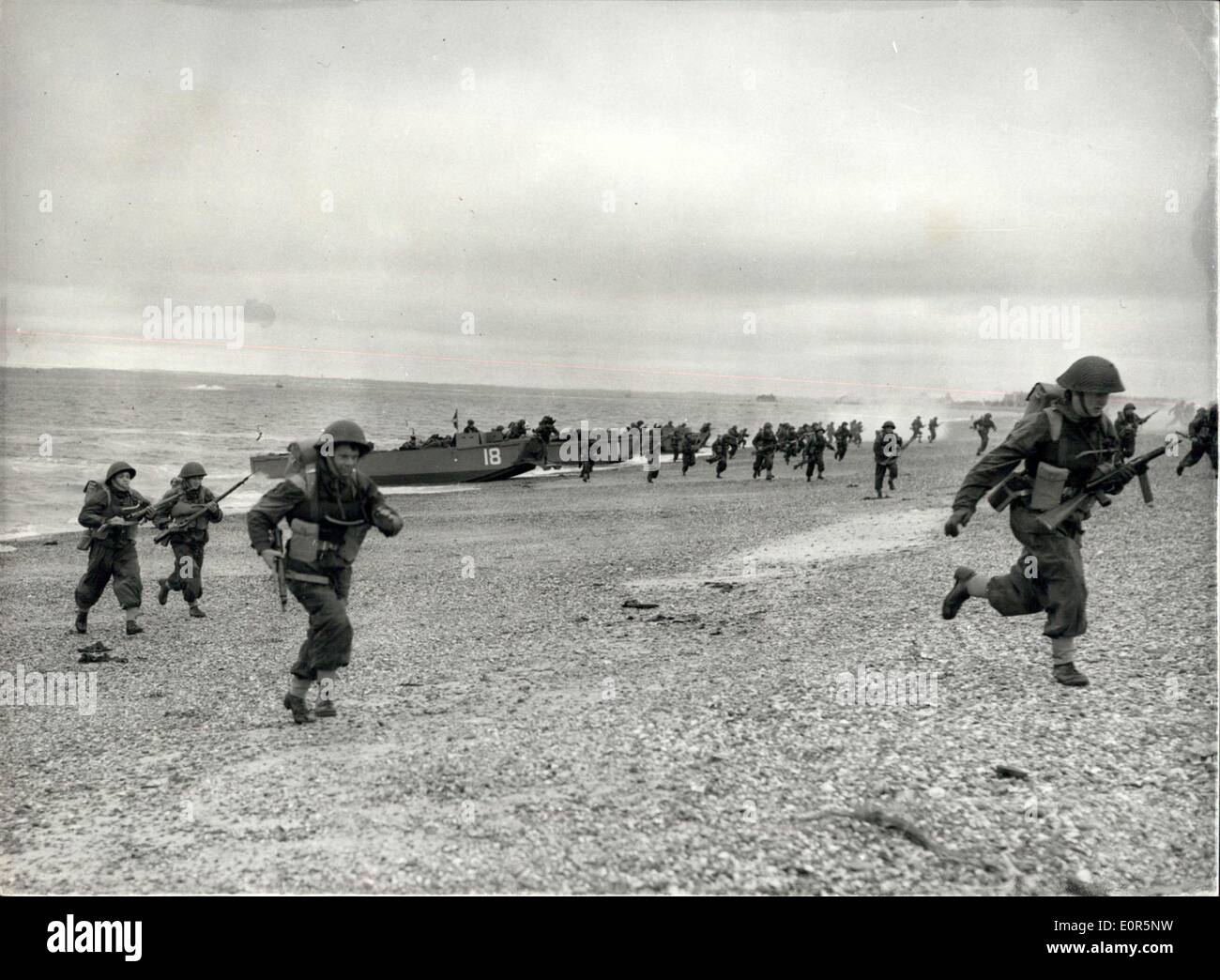 May 19, 1958 - Exercise ''Run Aground XI'' - at Southsea: Exercise ''Run Aground XI'' - was carried out on the Eastney Beach, Southsea, today - in which staff College Students saw some of the craft - methods and equipment used in amphibious operations. The exercise included an assault by Royal Marine Troops mounted from a Commando Carrier - in helicopters. Photo Shows Scots Fusiliers - running up the beach - at Eastney today - making an assault landing from landing craft - during the exercise today. Stock Photo