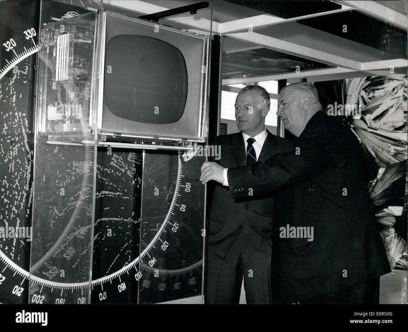 Apr. 04, 1958 - In the German pavilion on the international exhibition: we were meeting the''man of thousand tricks'', the former chief of the racing stud of the firm Daimler-Benz, Alfred Neubauer together with Karl Kling. But they didn't tell us whether they were coming clear of the Siemens-plexi glass television. Our picture shows: Alfred Neubauer (right side) and Karl Kling in the German pavilion, before the Siemens-plexi-glass-television. Stock Photo