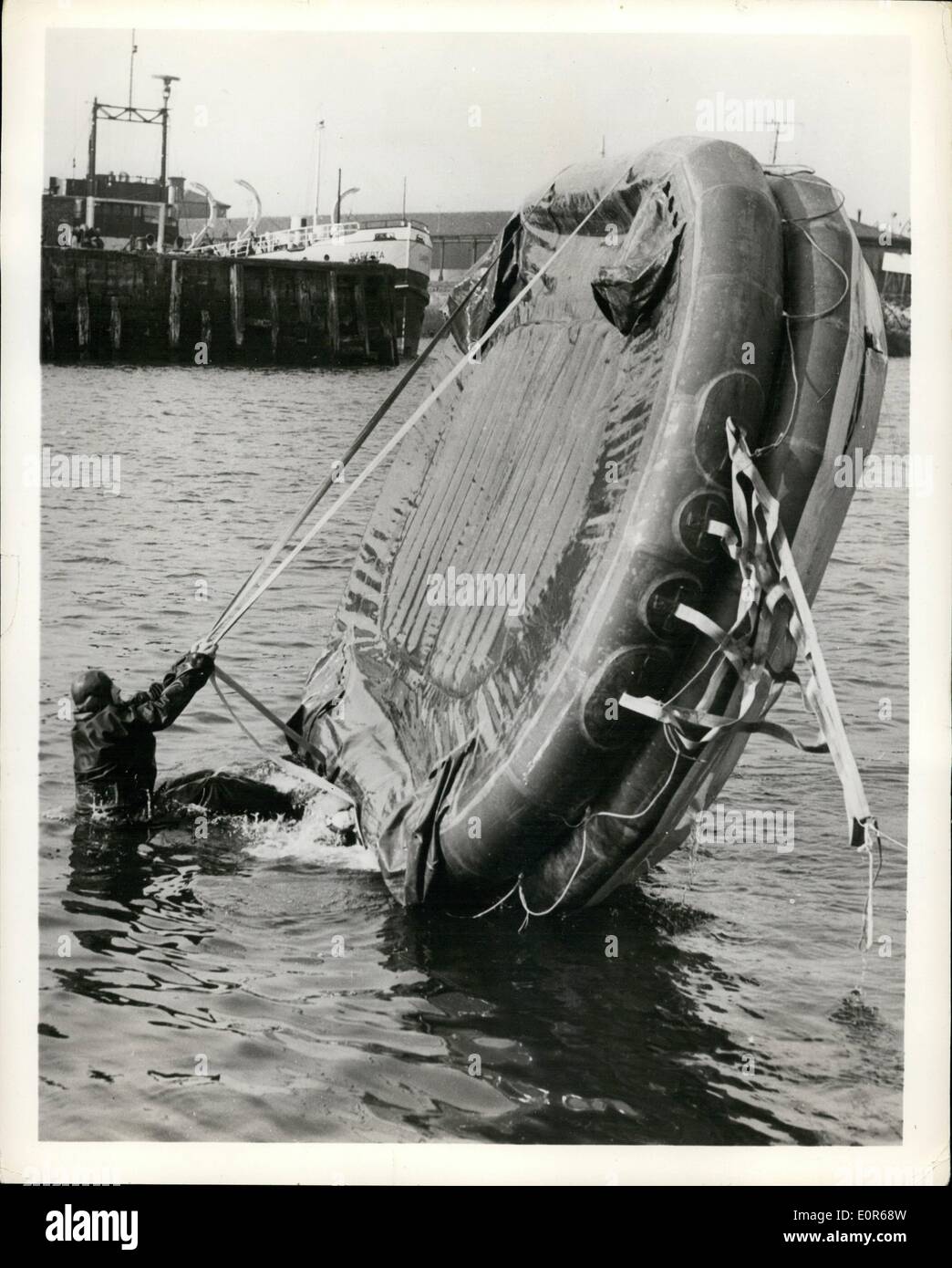 Apr. 04, 1958 - A demonstration was recently held in Greeenock, Scotland, of inflatable liferafts which are becoming increasingly popular in Britain and will soon be compulsory in many types of vessels. Speed was a feature of the demonstration, the average raft being inflated and boardable in 30 to 45 seconds. Photo shows demonstrator shows how to right an upturned 25-man Elliot Liferaft. Manufacturers: Elliot Equipment Ltd, Llwynpia, Rhondda, South Wales. Stock Photo