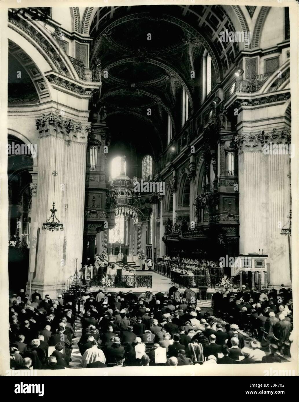 May 05, 1958 - Queen attends dedication at St. Paul's . H.M. the Queen and the Duke of Edinburgh today attended a service for the re-dedication of the restored eastern part of St. Paul's Cathedral and the dedication of the new high Altar as a memorial to the 335, 451 men and women of the commonwealth overseas who died in the two worldwars. Photo shows the Archbishop of Canterbury during the Consecration showing the Queen and the Duke of Edinburgh seated at St. Paul's cathedral today. Stock Photo