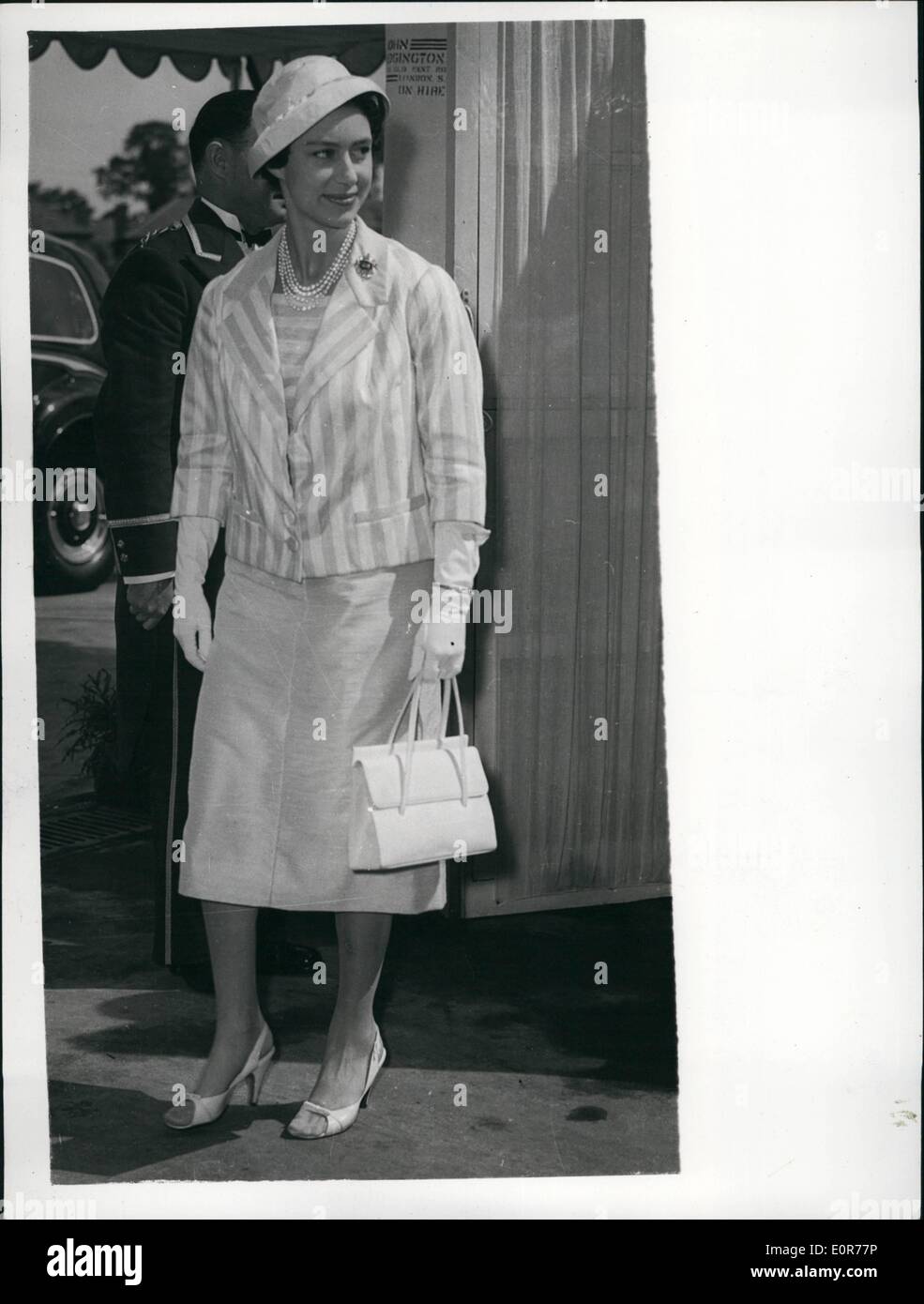 May 05, 1958 - The ''Sunshine Prince'' Princess Margaret At Greenford: Princess Margaret wore a fashionable pale silk summery outfit when she visited Greenford, Middlesex today. Her striped blaser was worn over a matching blouse with a skirt picking up the darker stripes. Her peep-toe sandals and large satin hat with turn - down brim completed the ensemble. Stock Photo