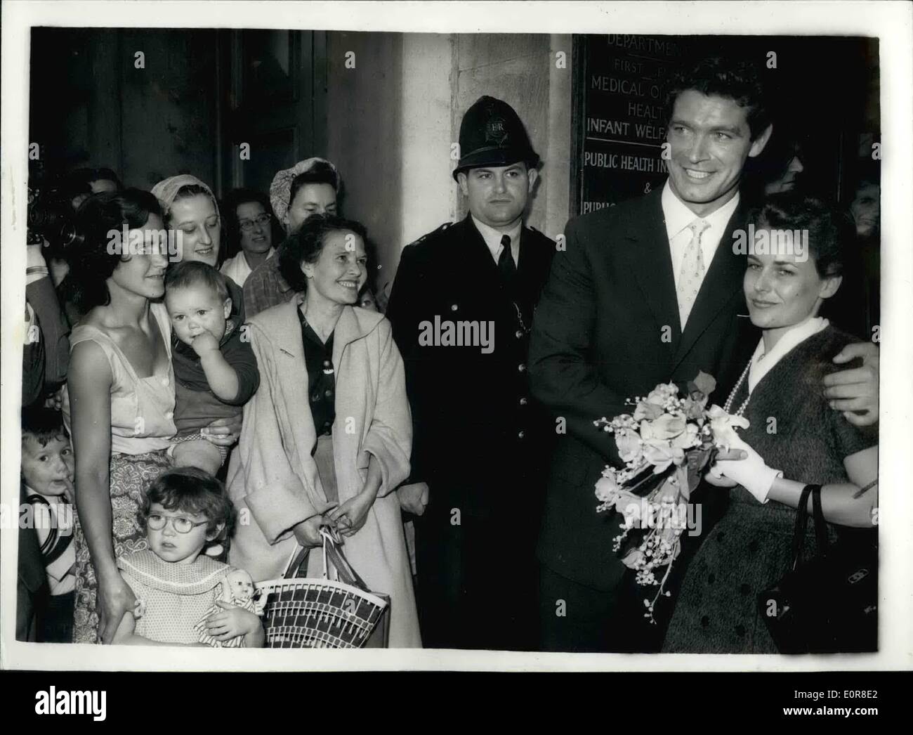 Aug. 08, 1958 - Irish screen actor marries Italian girl at Fulham register office.: Stephen Boyd, the Irishman who rose from a cinema commissionaire in Leicester Square to a 350-a-week film star, was married today to pretty Italian girl Mariella di Sarzana, at, Fulham Register Office. The couple will fly back to Rome for Stephen to resume worn on Monday on a new film version of ''Ben Hur''. Photo shows the happy couple pose for their picture watched by some of the people who gathered outsider the register office to see the couple. Stock Photo