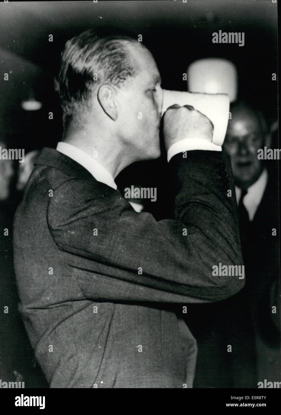 Jul. 07, 1958 - Royal Visit to Brussels fair.The Duke sinks a pint.: H.R.H. The Duke of Edinburgh pictured yesterday as he sinks a pint of bitter at the Britannia Inn - the typical English pub at the Brussels Fair - after he had made a tour of the British Pavilions. Stock Photo