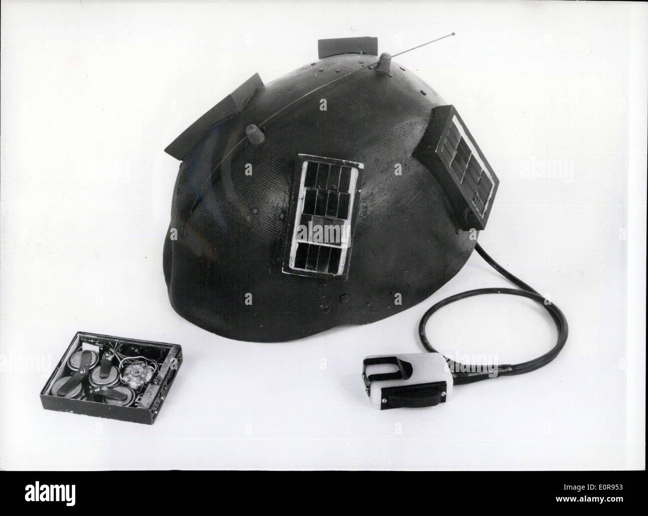 Jul. 12, 1958 - U.S. Helmet Radio designed to use the sun's rays to obtain electric power needed. The U.S. helmet radio currently being developed by the U.S. Army Signal Corps, is deisgned to use the sun's rays to obtain all electric power needed to operate both the transmitter and receiver for as long as a year. Long narrow clusters of tiny solar cells are paced on either side of the crown of the helmet. These silicon wafers power the radio fro normal daylight operation and charge four small nickelcadium storage batteries to supply peak current in daytime and operate the set at night Stock Photo