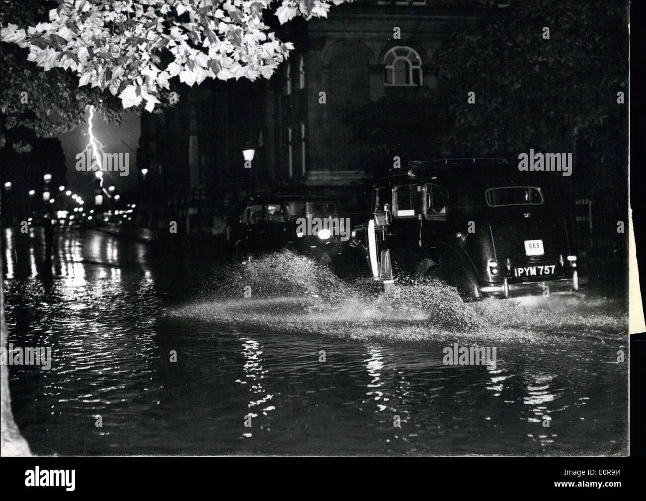 Sep. 09, 1958 - THE GREAT STORM: Much damage was caused last night in what was described as ''one of the most spectacular electrical storms of the century'' which swept the the South of England. Many homes were flooded and buildings damaged. Rail and road chaos was caused in the London area. Photo Shows:- Scene during the storm in London last night. On the left, a streak of lightning splits the sky over Westminster Bridge, whilst in the foreground a taxi ploughs its way through deep floodwater in Bridges Walk. Stock Photo