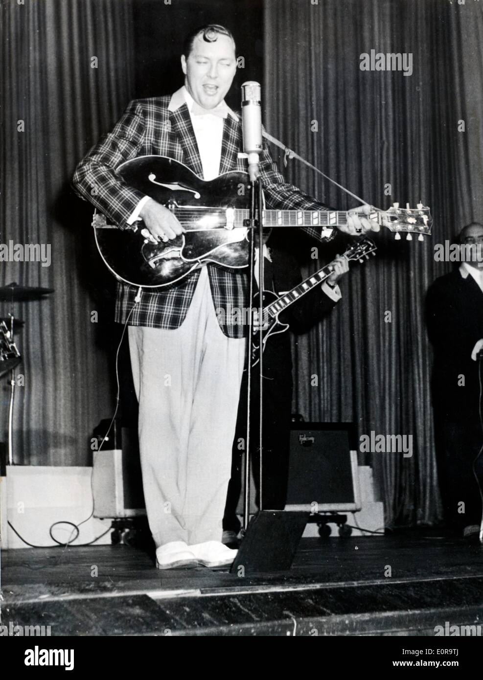 Bill Haley on stage playing guitar and singing at a concert Stock Photo