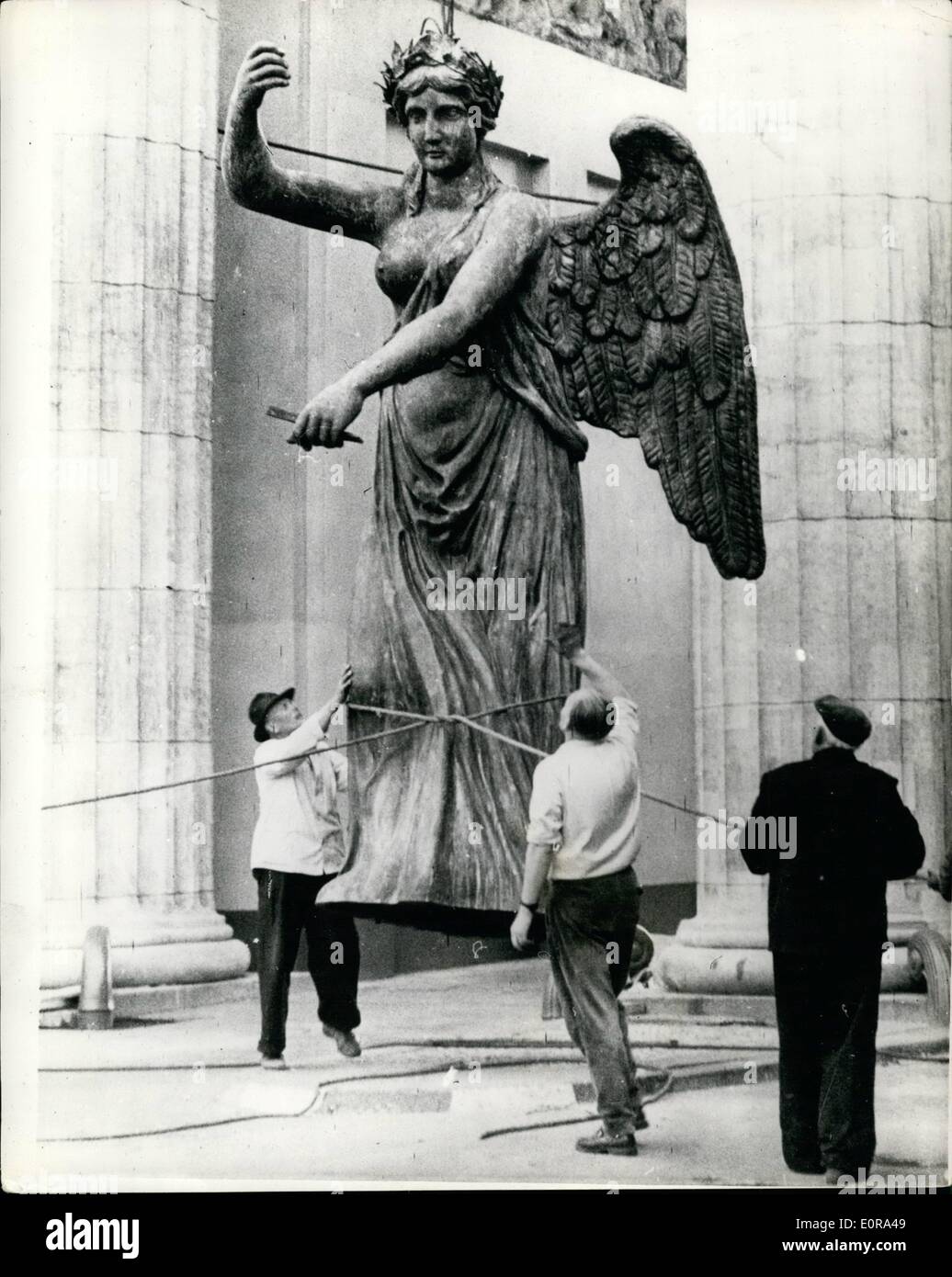 Sep. 09, 1958 - Berlin gets her ''Goddess of Victory'' back but without her iron cross and Prussian eagle standard.: Berlin's Goddess of Victory was restored to her chariot on top of the Brandenburg Gate between East and West Berlin recently but she was empty-handed, without the symbols of Prussian militarism. The statue was one of Berlin's most famous monuments and was destroyed by Russian artillery in World War II. Recently the two section decided to collaborate the statue was completely recast with standard which showed the Iron Cross and Prussian Eagle, and handed over to East Berliners Stock Photo