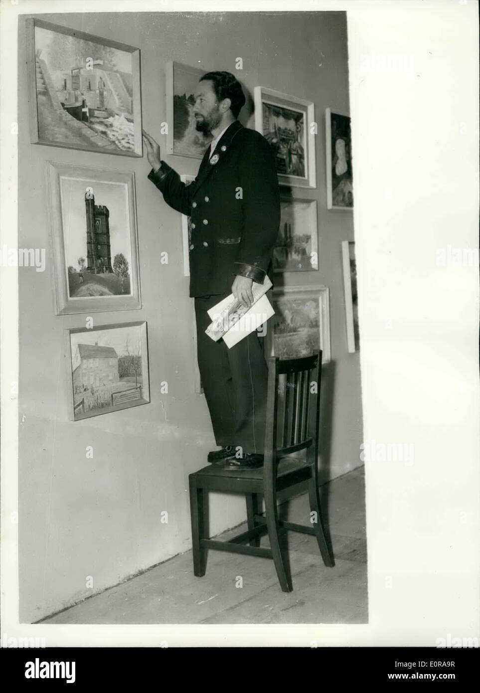 Nov. 11, 1958 - Annual exhibition of London Transport art group. No ''Standing Embargo'' here. Photo shows Mr. L.J. Hind a bus driver from West Drayton stands on a chair to view his painting ''Into the Locks'' at the Anuual Exhibition of the London Transport Art Group at Charing Cross Underground Station this morning. Stock Photo