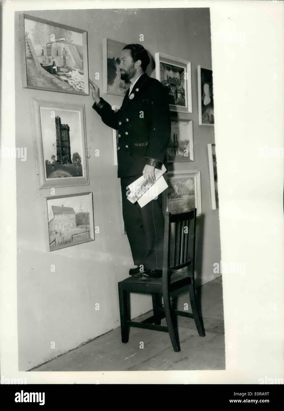 Nov. 11, 1958 - Annual Exhibition of London transport art group. ''standing embargo'' here... Photo shows:  Mr. L. J. Hind a bus driver from West Drayton - stands on a chair to view his painting ''into the locks'' - at the annual exhibition at the London transport art group - at Charing Cross underground station this morning. Stock Photo