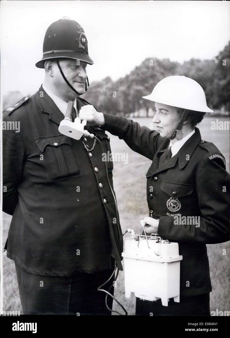 Oct. 03, 1958 - Civil Defense Exhibition in Hyde Park: Photo shows Mrs. Florence Francis, of the Islington Civil Defense Division, seen demonstrating a nuclear warfare contamination meter on P.C. Smith of Hyde Park Police Station, at the Civil Defense Exhibition, which opened in Hyde Park today. Stock Photo