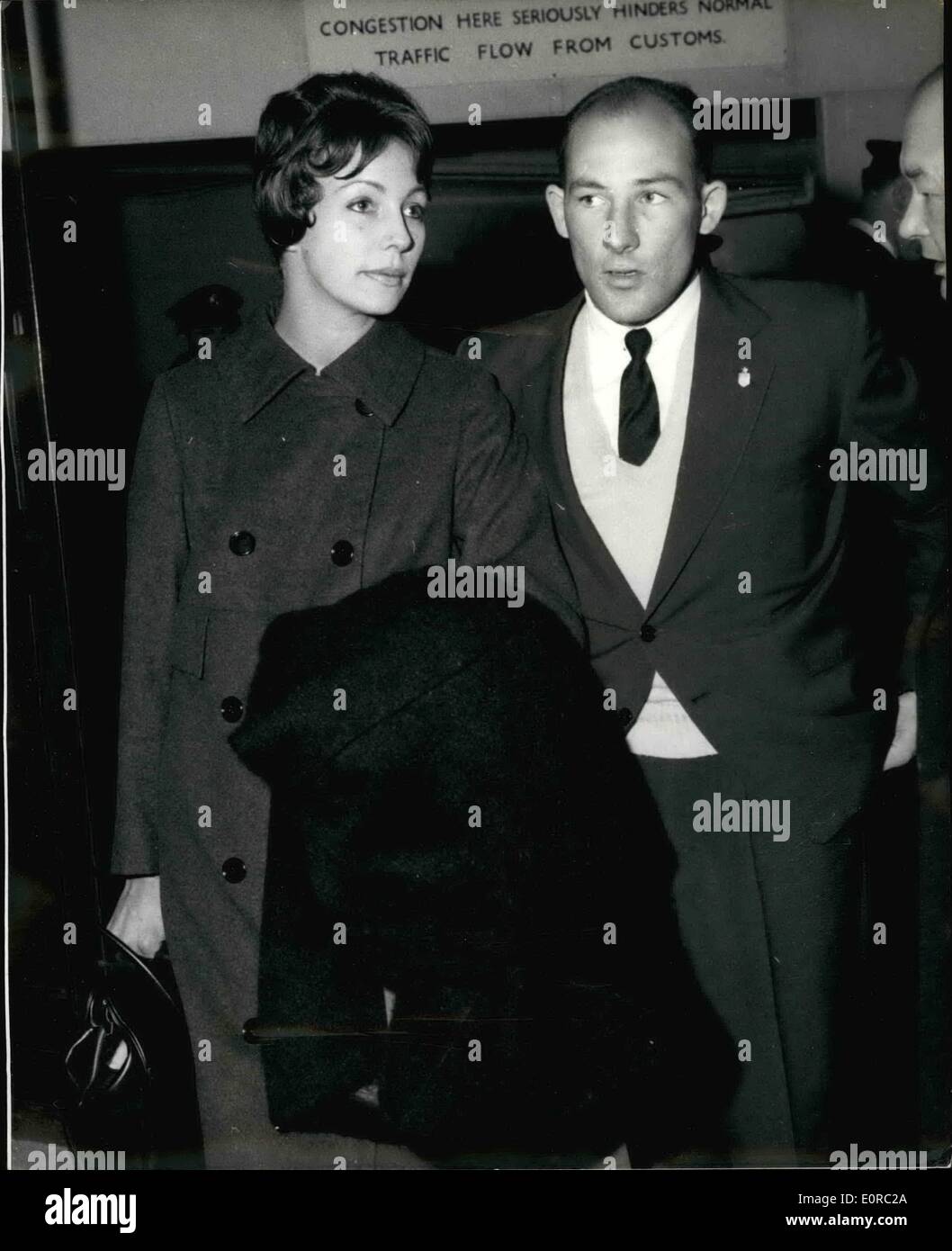 Jan. 01, 1959 - Stirling Moss and his wife arrive home. Photo shows Motor racer Stirling Moss and his wife on their arrival at London Airport last night from a holiday in Bangkok after he had won the Grand Prix races in Australia and New Zealand. Stirling said he was 'staggerd' by the death of his friend and fellow racing driver Mike Hawthorn. Stock Photo
