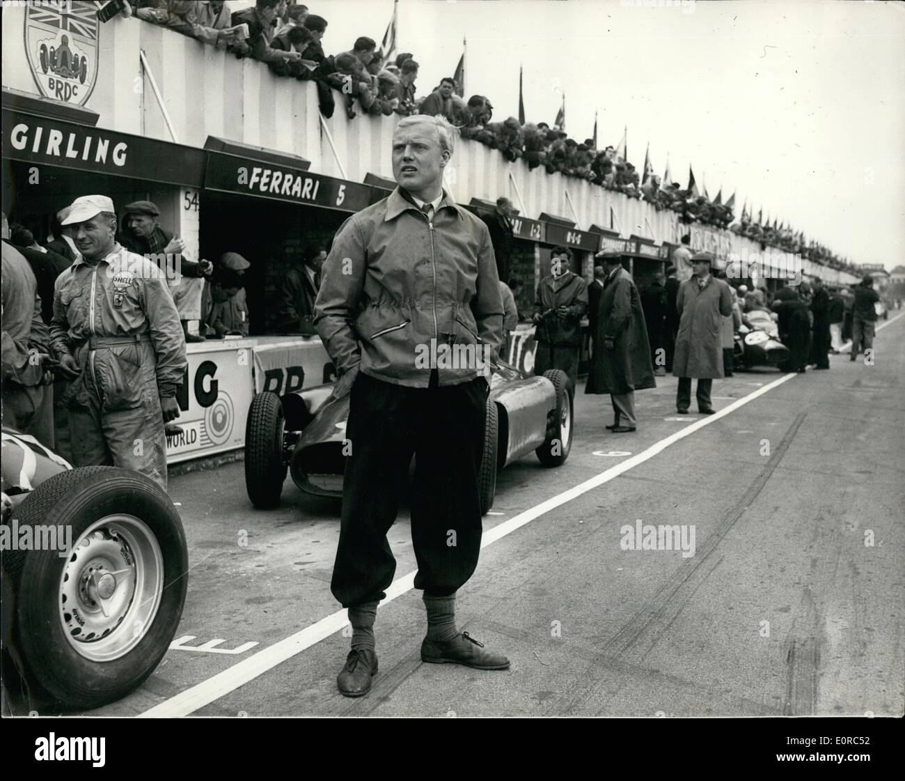 Jan. 01, 1959 - Mike Hawthorn killed when car hits tree flashback - Silverstone 1956: Mike Hawthorn, Britain US world champion racing driver died yesterday when his Jaguar car skidded on the wet road and crashed into a tree near Guildford, Surrey. He was only 29 and retired holding the championship title. Photo shows Silverstone 1956 - Mike Hawthorn stands on the track - wtih a background of racing cars and pits. Stock Photo