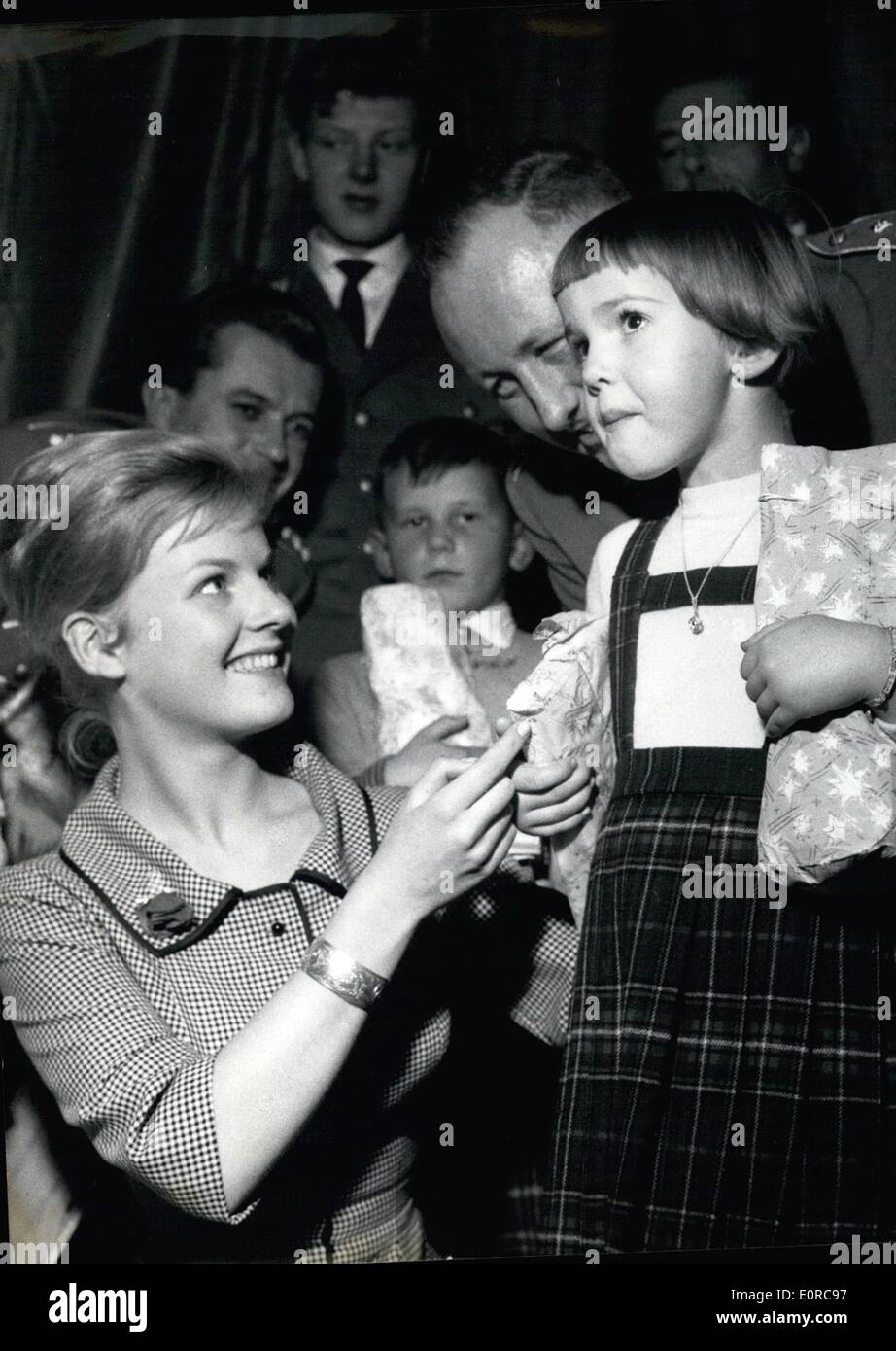 Dec. 12, 1958 - The ''Bundeswehr'' Gives X-Mass Gifts to Children - Allover western Germany the German Army helds X-Mass Partyes for German Children. On there Occasions there is a lot of fun and the Children get toys and Sweetis Today (18.12.58) in Munich a X-Mass Party Tooks Part at the Lowenbrau-Cellar. More Than 500 Children had anice time and got present-parcels. OPS: Film-Actress Heidi Bruhl (Heidi Bruehl) and Lieutenant-Colonel Mayer (Mayer) - Right in the Picture- Giving Presented to a little gril. Stock Photo