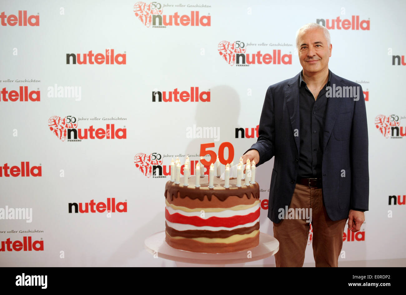 Dortmund, Germany. 18th May, 2014. Carlo Vassallo, CEO of Ferrero Germany, cuts into a birthday cake for the 50th birthday of Nutella at Westfalenpark in Dortmund, Germany, 18 May 2014. The Nutella from the Ferrero brand is celebrating the 50th anniversary with a family party and celebrity birthday sponsors. Photo: JONAS GUETTLER/dpa/Alamy Live News Stock Photo