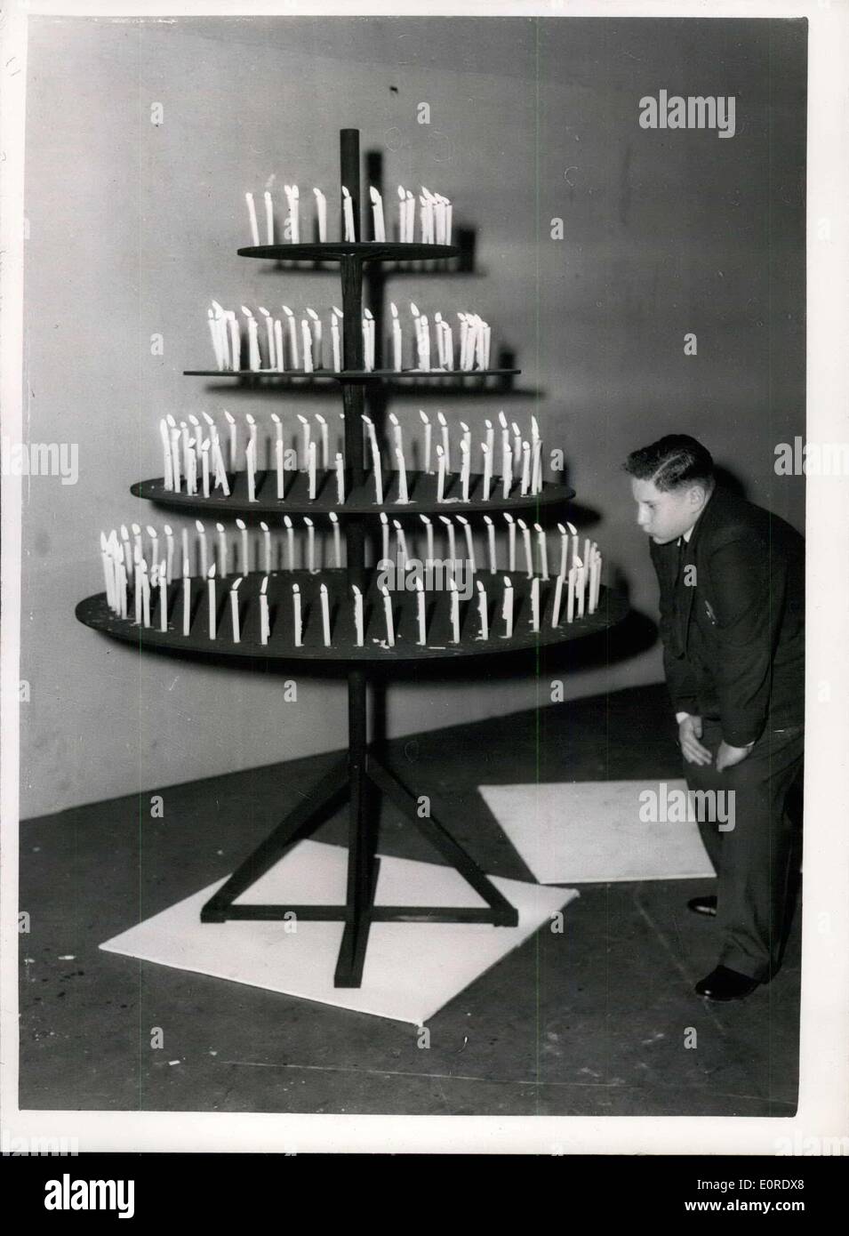 Apr. 02, 1959 - Candle Birthday 'CAKE': Today's Slimmers Clinic in the B.B.C Television programme ''Mainly for Women'', co-incides with the 17th birthday of one of the slimmers, Victor Shirman. For obvious reasons they are not giving him a birthday cake, but a candle to light for every pound that he has dropped. In addition there was a candle for every pound that all the other slimmers have dropped - a pyramid of something like 360 candles. Photo shows Victor Shirman blows out the candles - on his birthday today, at Lie Grove. Stock Photo