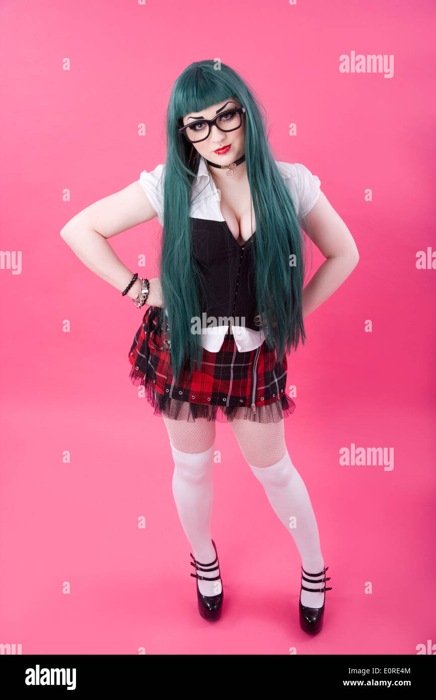 Gothic looking girl with a green wig wearing a tartan skirt. Stock Photo