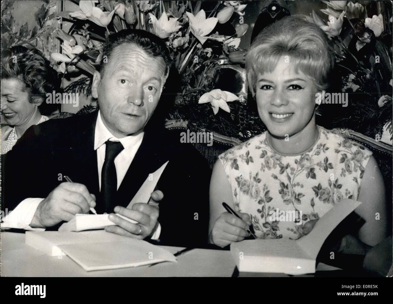 Apr. 04, 1959 - Sportsman and Author. Gilbert Prouteau, The well known French author and sportsman (FRENCH CHAMPION OF TRIPLE JUMP) autographed his new book ''The fear of women '' at his paris publisher's today. OPS Gilbert Prouteau autographic his book. Next to him the cinema actress Dora Doll Stock Photo