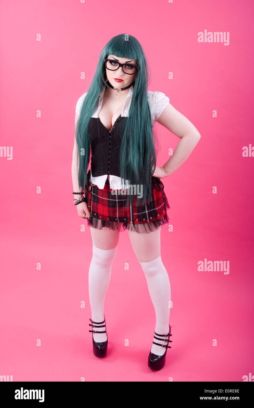 Gothic looking girl with a green wig wearing a tartan skirt. Stock Photo