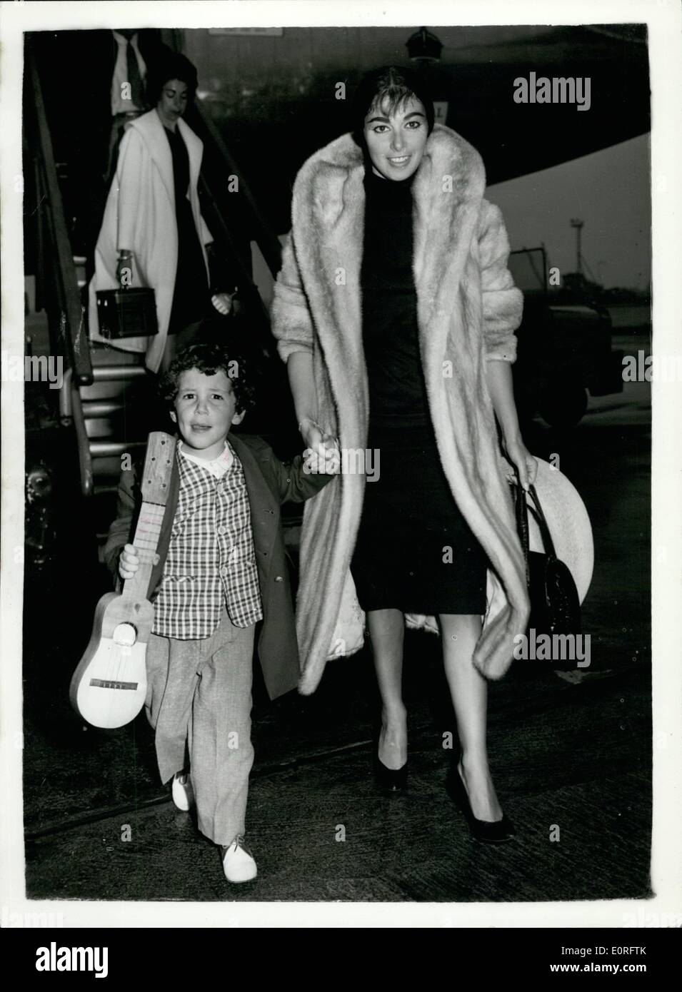 May 05, 1959 - Pier Angeli And Her Three-Year-Old Son Fly Into London Airport From Las Palmas: Two angry film stars - Eva Bartok and Pier Angeli - stranded with their children yesterday at Las Palmas airport, eventually got away from there by air today. Eva and Pier who had been filming in ''S.O.S.Pacific'' in the Canary Islands, should have flown back to England yesterday with the rest of the film unit. But airline officials told them they could not take their children with them because of a ruling that only passengers who had flown out by the chartered airplane could fly back by it Stock Photo