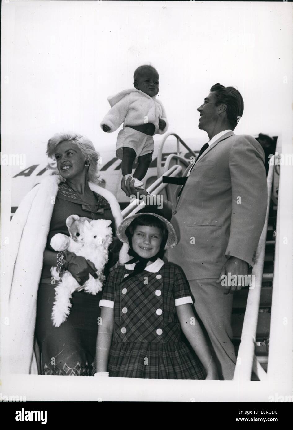 Jul. 07, 1959 - Jayne Mansfield Arrives: Jayne Mansfield, who is to star in a new British film, the Wigmore Production ''Too hot to handle'', arrived at London Airport today with her husband, Micky Hargitay and her nine-year old daughter Jayne Marie and baby son Miklas. Photo shows Jayne Mansfield, with daughter, Jayne Marie Marie, ad husband; Mickey Hargitay holding baby son Miklas on his head-on arrival at London Airport today. Stock Photo