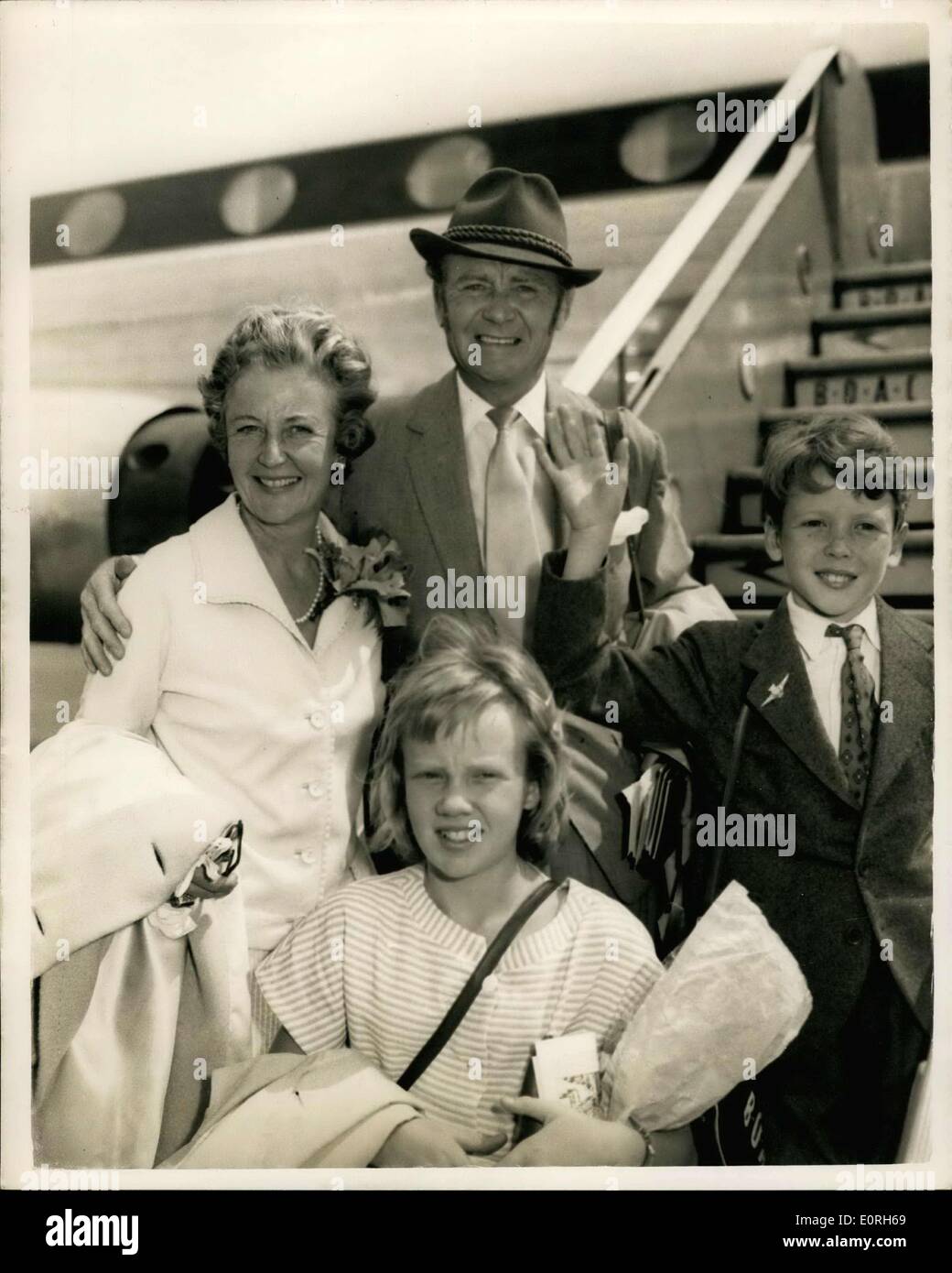 Jul. 15, 1959 - John Mills And Family Leaves For Hollywood Ready For ''Swiss Family Robinson''; Actor John Mills was accompanied by his family when he left London Airport this morning for Hollywood - for talk on the new film ''Swiss family Robinson'' which is to be made at Tobago,. John wore ''sideboards'' - preparation for the new film. Photo Shows John Mils his wife, novelist, Mary-Hayley-Bell, their daughter Hayley and son Johnathan when they left London Airport this afternoon. Stock Photo