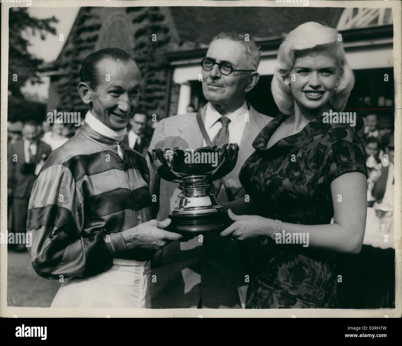 Sep. 09, 1959 - Variety Club race meeting at Sandown Park. Stars attend: Many famous stars this afternoon attended the race meeting at Sandown Park, sponsored by the Variety Club of Great Britain, in aid of Children's charities. Photo Shows Jayne Mansfield presents the Gold Cup to Australian jockey George Moore, who received it on behalf of Prince Aly Khan, after the latter's horse Sallymount, ridden by George Moore, had won the Lyons Maid Stakes at Sandown Park today. Stock Photo