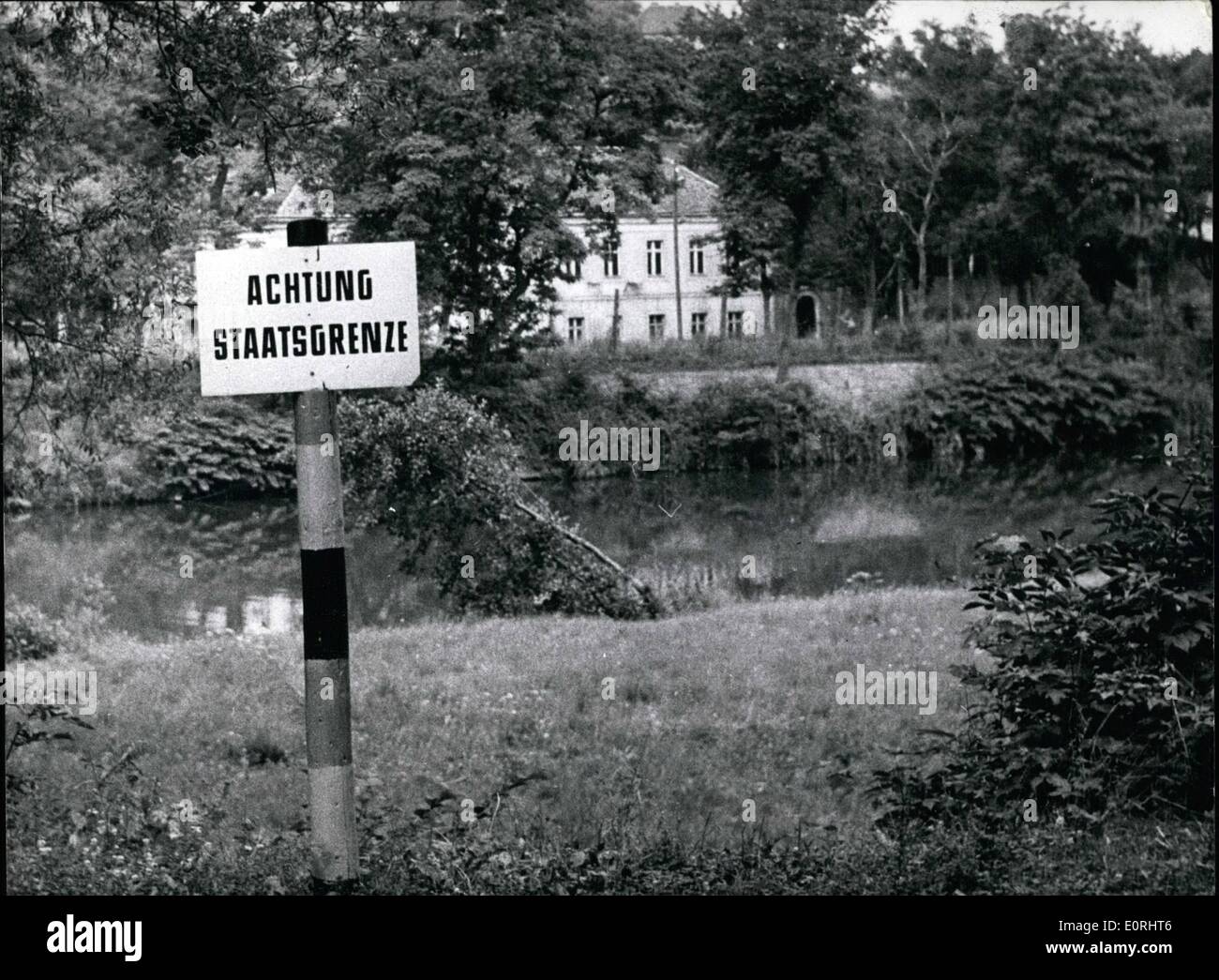 Sep. 09, 1959 - Oder-Neisse-Border is ''Stateborder'': 20 years ago, on the 1st Sept. 1939, Poland was invaded by Hitler's SS. When the Russians set Poland free there was drawn a provisional border in 1945 between Germany and Poland; the ''German Democratic Republic'' and Poland made a ''stateborder'' of that. Photo shows was taken in Aug. 1959 at the Neisse near Gorlitz (GORLITZ). The sign in front is on german ground; the house on the other side of the river Neisse belongs already to Poland. Stock Photo