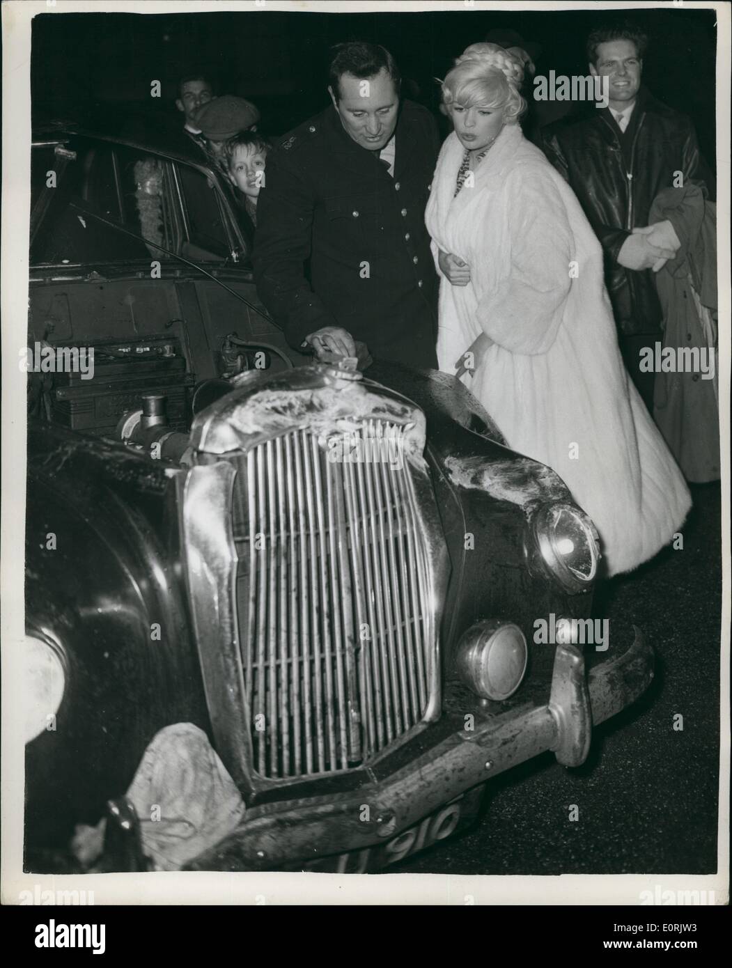Dec. 12, 1959 - Jayne Mansfield and Joe Powell look at the damaged car after the filming of the crash for the new film '' The Challenge'' at Twickenham. Stock Photo