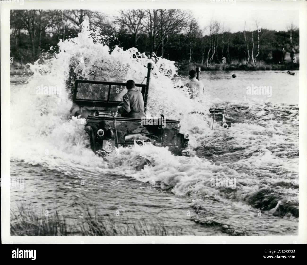 Dec. 12, 1959 - Military, mechanical ''Grand national'' in waves and awake two waterproofed ''Champ'' vehicles speed across a five -feet deep pond. They were competing in the British army mechanical transport championship at Bordon, Hampshire, England. The contest, over a tough cross - country course, is Britain's mechanical and military ''Grand National' Stock Photo