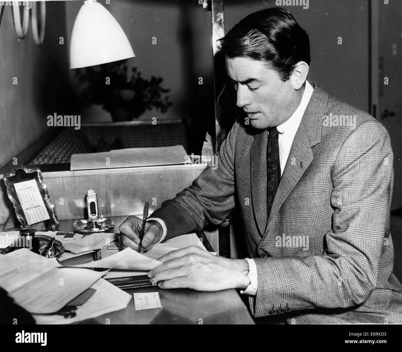 Actor Gregory Peck writing in his London hotel Stock Photo