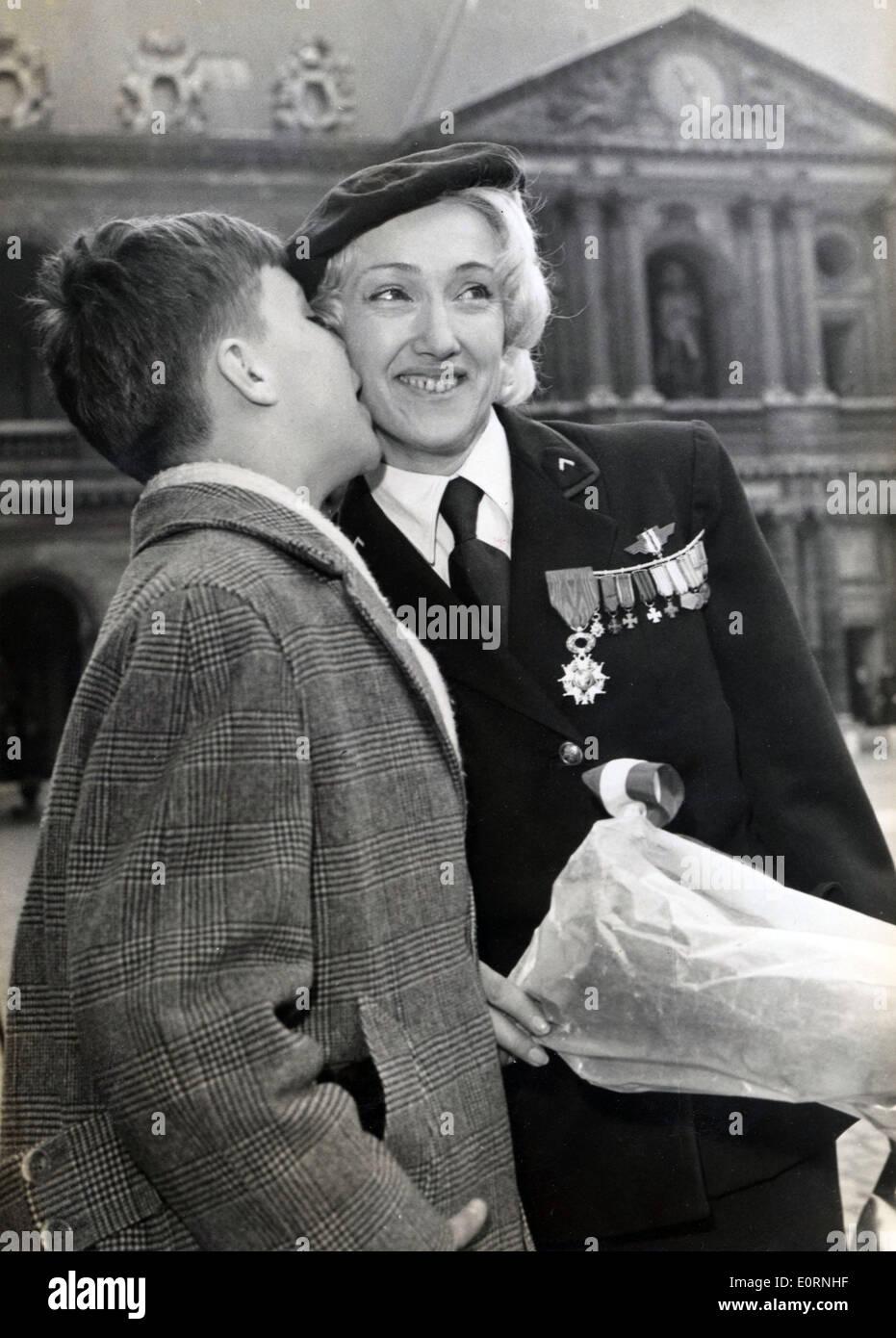 Mar. 12, 1960 - Paris, France - Dancer LYDIA LOVA is kissed on the cheek by her ten year old son PATRICK after receiving her Legion of Honor for her work as a member in the French Resistance. Stock Photo