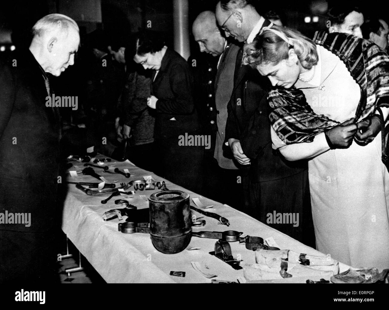 People looking at torture instruments by which prisoners of concentration camps were tormented Stock Photo