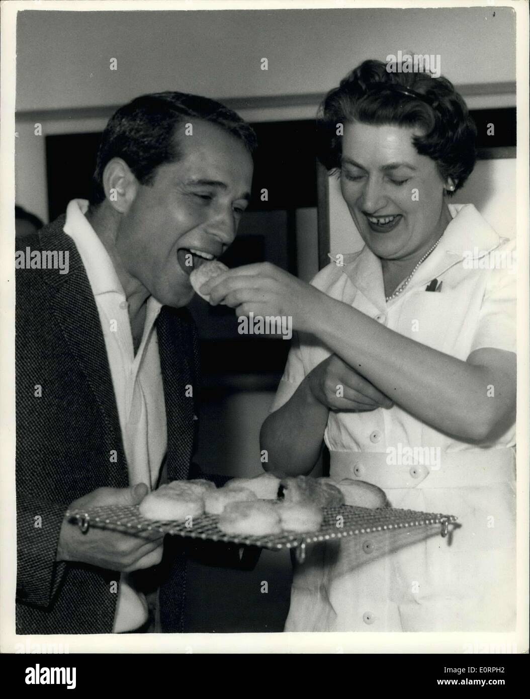 Apr. 22, 1960 - Perry Como Tours Offices Of The Kraft Company In London: Perry Como-who is said to be the world's highest paid TV star-this afternoon paid a visit to the Marylebone Offices of the Kraft Company-the company which sponsors his shows. Photo shows. Perry Como tries out a scone prepared by Mary Tracey of Helenborough, near Glasgow-who is the Company's chief experimental Cook-at the offices this afternoon. Stock Photo