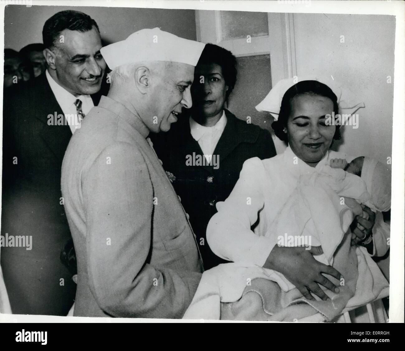 May 05, 1960 - Mr. Nehru visits hospital- at Inchass - during Egyptian tour.: Indian Prime Minister Mr. Nehru was escorted by President Nasser during his visit to Inchass - to see the Agrarian Reform. He distributed certificates to land owners - and toured hospitals etc. Photo shows Mr. Nehru admires a newly born baby - during his visit to Inchass - Pres. Nasser looks on. Stock Photo