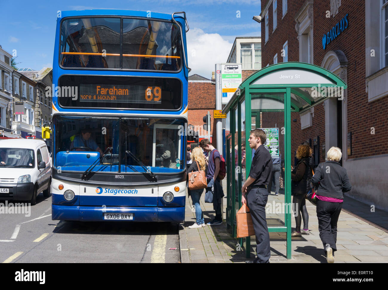 People boarding a bus at a bus stop, UK Stock Photo