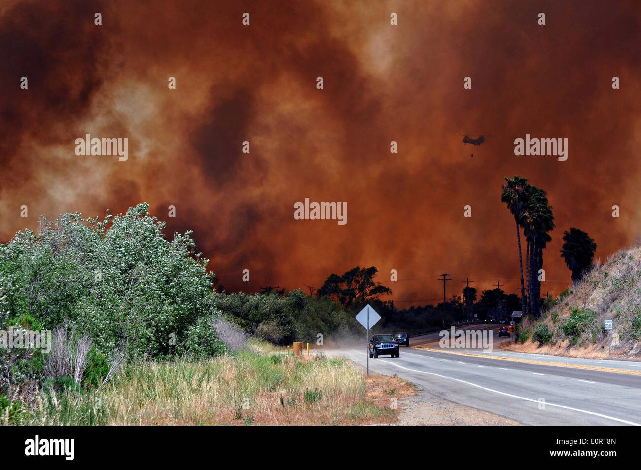 The Las Pulgas wildfire burns along a roadway in the foothills around the Marine Corps Air Station May 16, 2014 in Camp Pendleton, California.  The Las Pulgas Wildfire on Camp Pendleton has burned more than 15,000 acres and is the largest fire in San Diego County history. Stock Photo