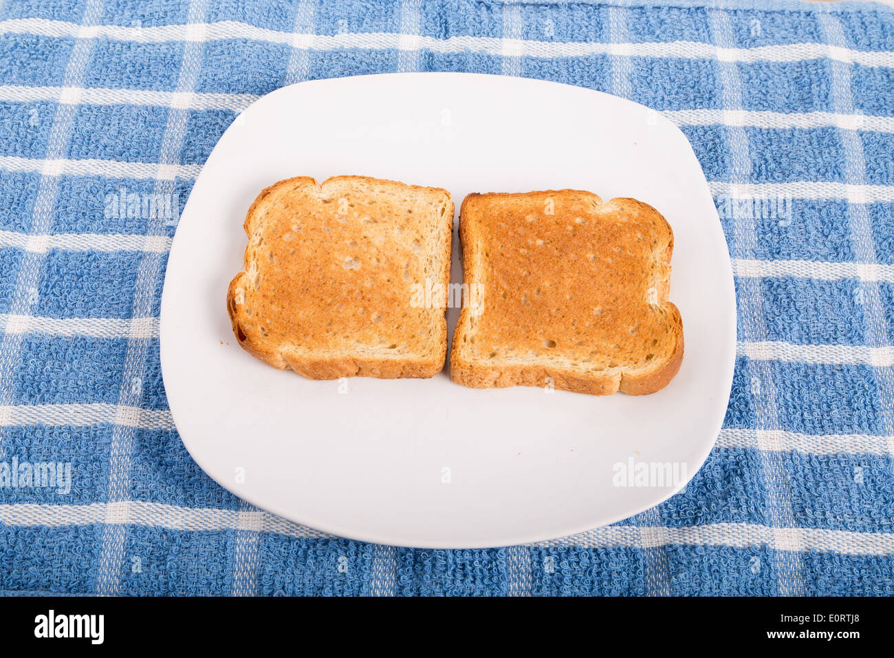 Two pieces of toasted whole wheat bread on a white plate Stock Photo ...