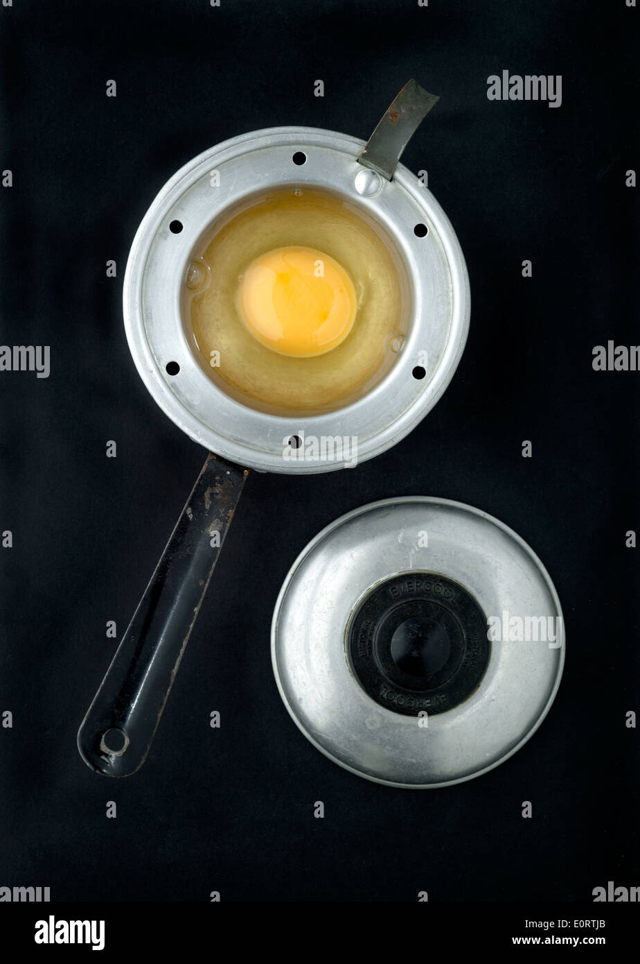 Vintage Egg Poacher with raw Egg ready for poaching Stock Photo