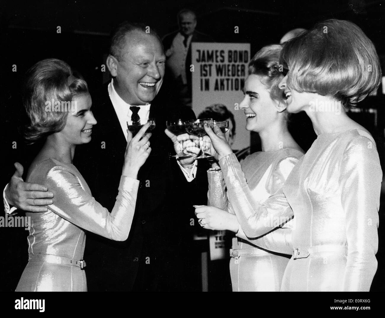 Actor Gert Frobe chats with women at party Stock Photo