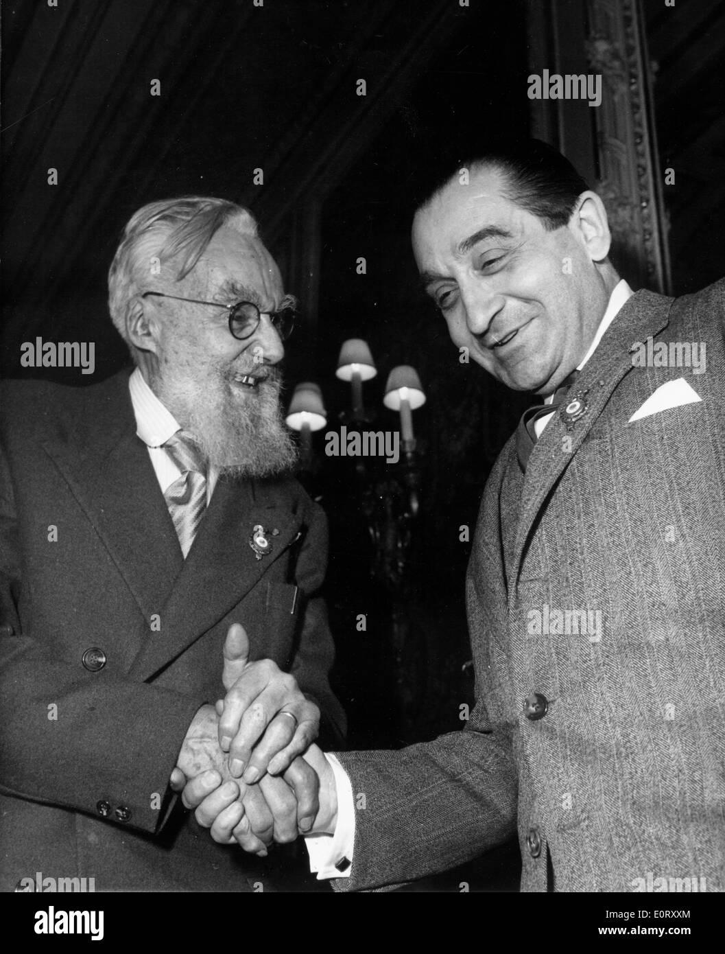 French politician PIERRE MENDES-FRANCE laughs and shakes hands with an older man. Stock Photo