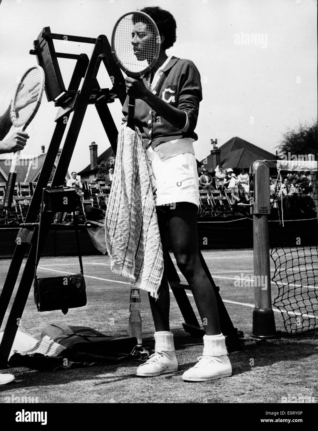 Tennis pro Althea Gibson cleans racket during a match Stock Photo