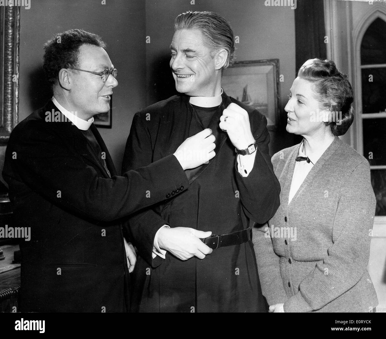 ROBERT DONAT, center, dressed as the Rev. William Thorne in the 1954 film 'Lease of Life', speaking to cast members on set. Stock Photo