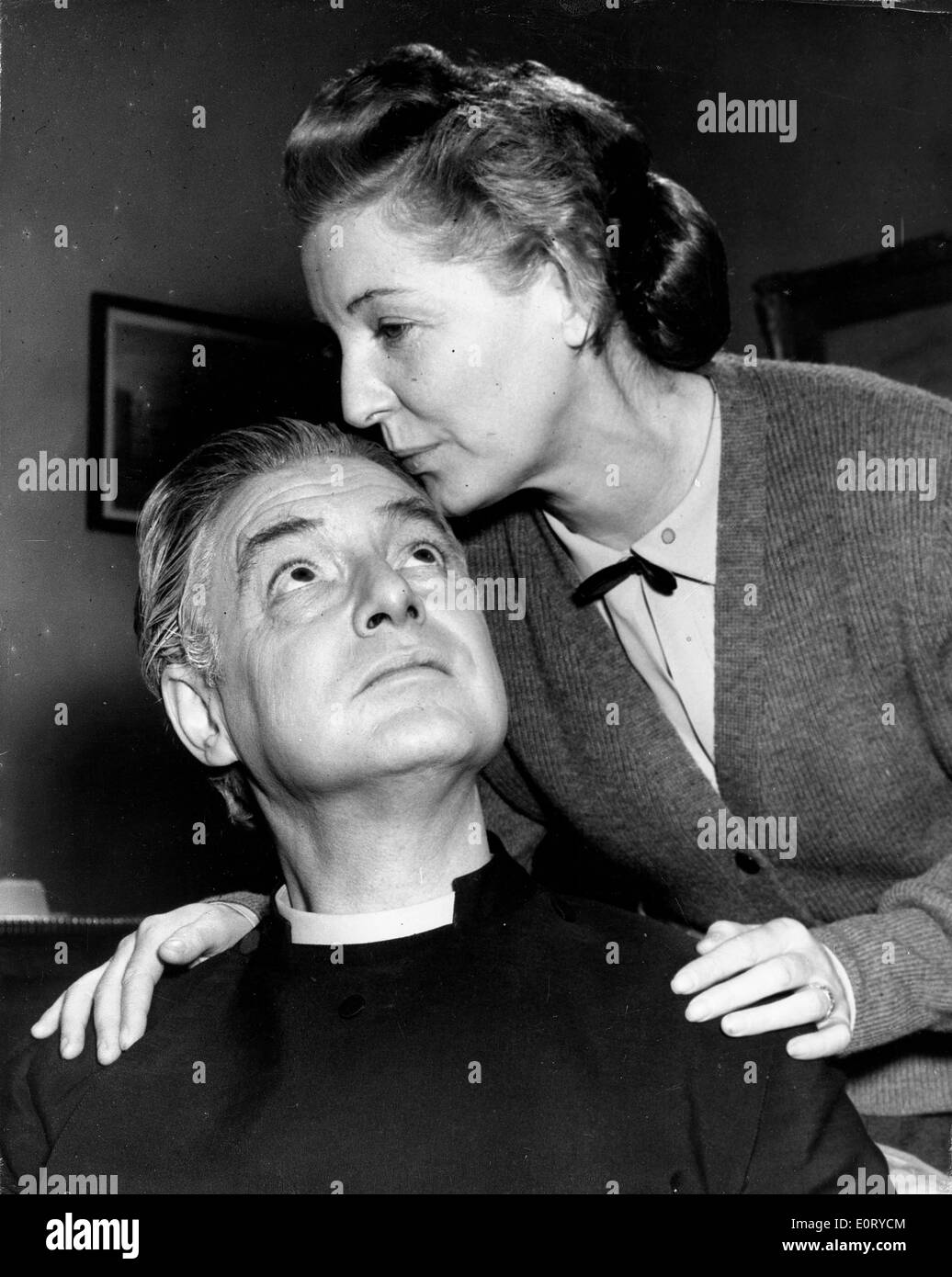 ROBERT DONAT, dressed as the Rev. William Thorne in the 1954 film 'Lease of Life', gets a kiss on the forehead from cast member. Stock Photo