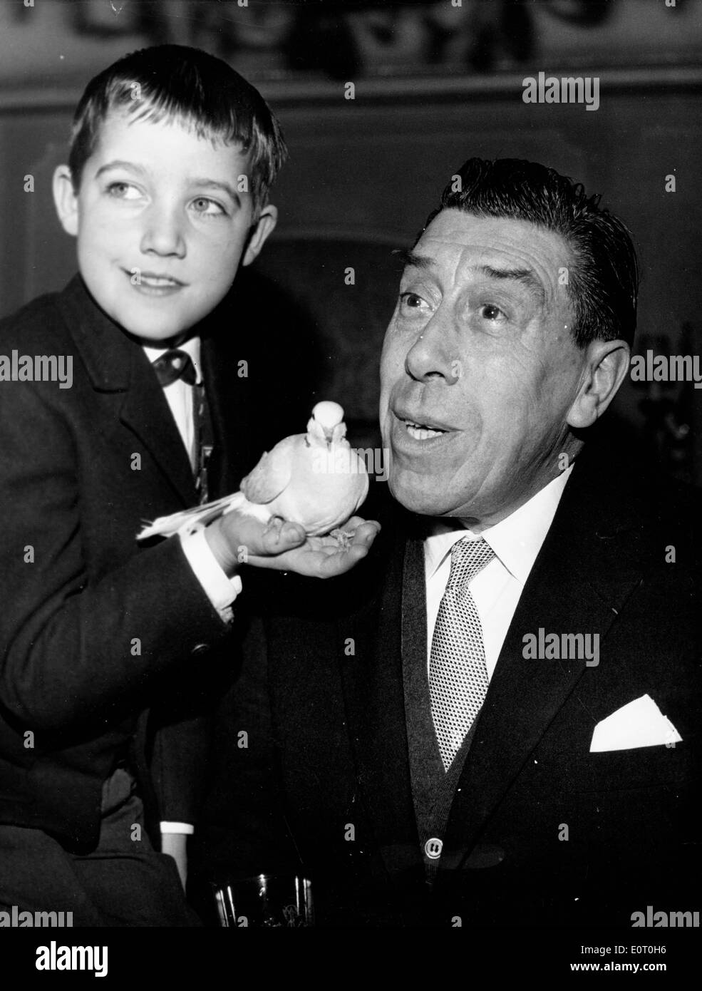 Actor Fernandel with young boy holding bird Stock Photo