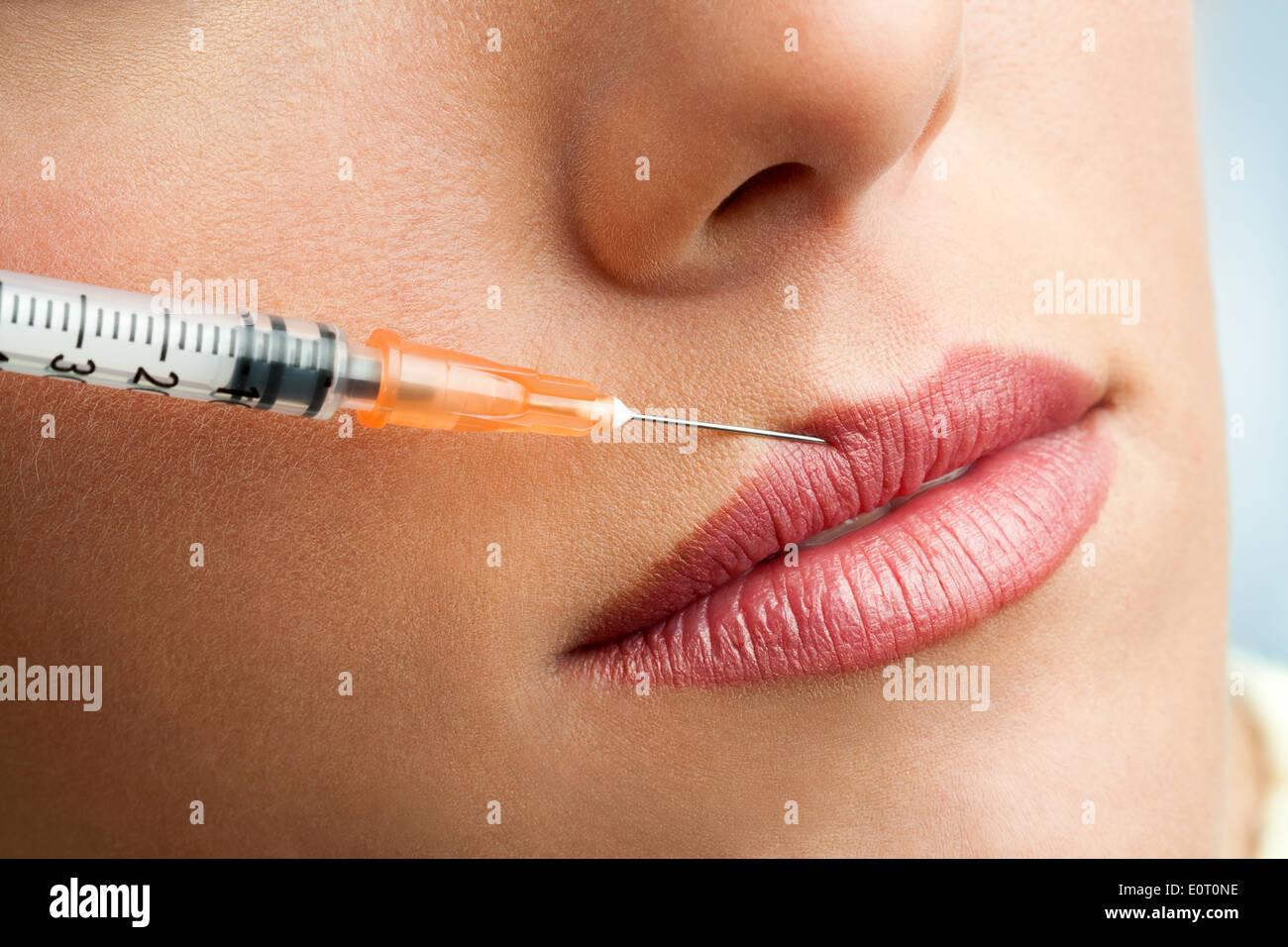 Close up of syringe injecting botox into female lips. Stock Photo